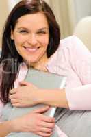 Smiling woman embracing her digital tablet