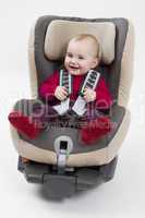 toddler in booster seat for a car in light background