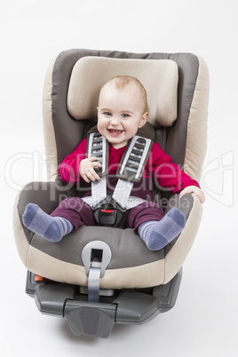 happy child in booster seat for a car in light background