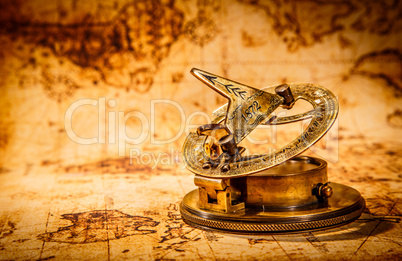 Vintage compass lies on an ancient world map.