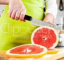 Woman's hands cutting grapefruit