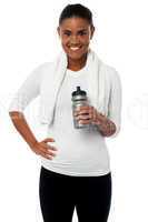 Fitness freak holding sipper, towel around her neck