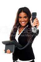 Cheerful businesswoman holding a telephone