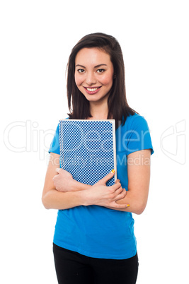 Smiling young confident student holding notebook