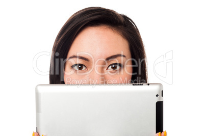 Asian model hiding her face with tablet device