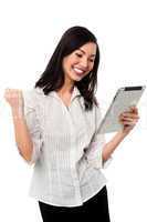 Excited businesswoman holding touch pad