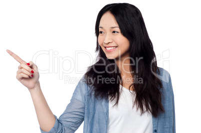 Young chinese girl pointing and looking outside