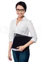 Smiling female executive holding business files