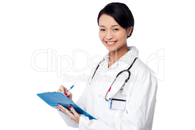 Pretty female doctor writing prescription