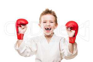 Smiling karate champion child boy gesturing for victory triumph