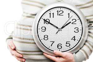 pregnant woman hand holding large office wall clock showing time