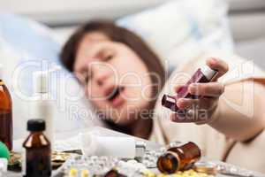 Woman patient in bed hand holding asthmatic inhaler