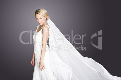 young blonde beautiful bride on grey