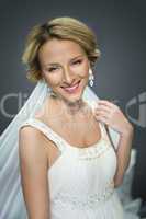 young blonde beautiful bride on grey