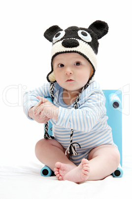 beautiful baby boy with knitted hat sitting