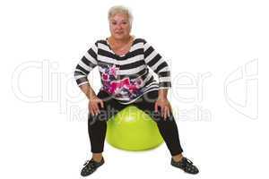 Seniorin sitzt auf Gymnastikball