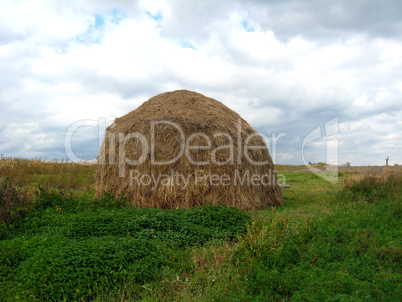 big stack of hay in field