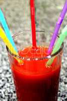 glass of tomato juice with multi-coloured tubules