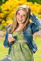 Perky female teenager texting in the park