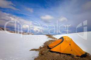 orange tent in snow mountains