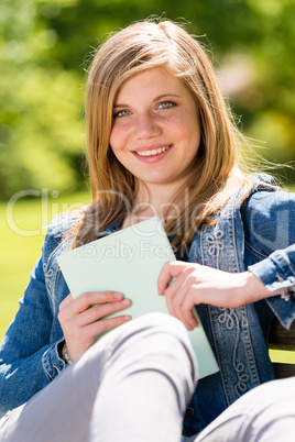 Teenage student sitting outside enjoying sunshine