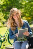 Teenage girl holding digital tablet in park