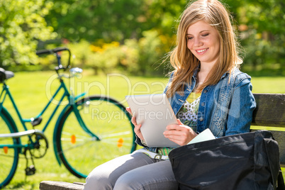 Young girl reading on tablet sunny day