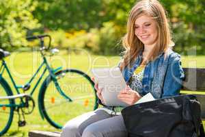 Young girl reading on tablet sunny day
