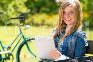 Adolescent girl using tablet computer in park