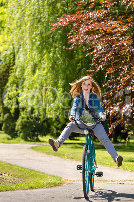 Carefree teenager riding bicycle across the park