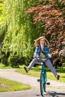 Carefree teenager riding bicycle across the park