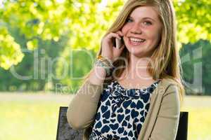 Smiling young girl using her mobile phone