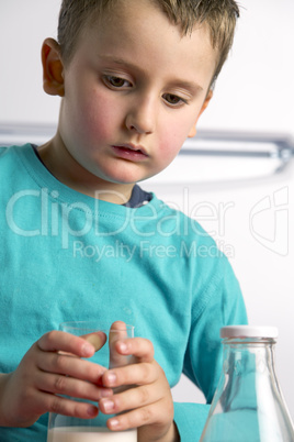 Child drinks a glass of fresh milk after playing