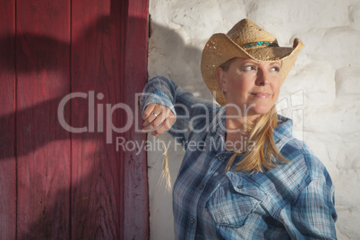 Beautiful Cowgirl Against Old Wall and Red Door