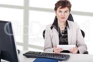 Businesswoman in office with tablet PC