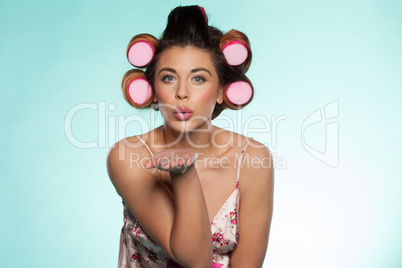 sexy woman in curlers blowing a kiss