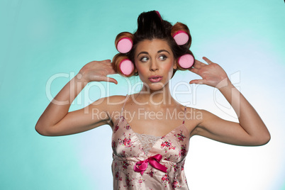 vain pretty young woman showing her hair rollers