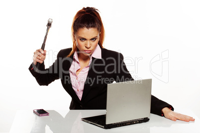 angry woman raising a hammer to her laptop