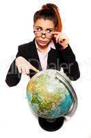 businesswoman looking dumb pointing to a globe