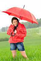 Happy young woman standing in the rain