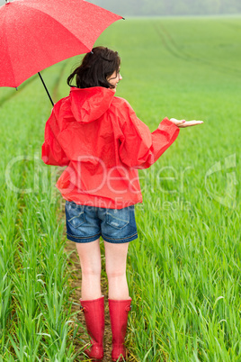 Woman standing in raincoat and with umbrella
