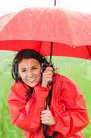 Wet young girl enjoying rainfall with umbrella