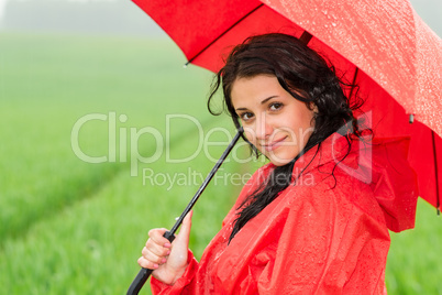 Smiling woman looking at camera during rainfall