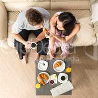 Carefree couple eating breakfast together