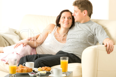Smiling couple eating breakfast on their honeymoon