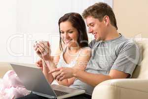 Cheerful couple using laptop together