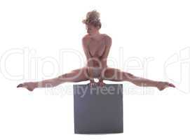 Pretty naked blonde dancing on cube in studio