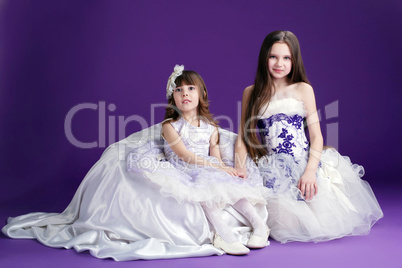 Pretty little girls posing on purple background