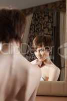 Reflection of attractive young brunette in mirror