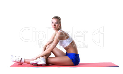 Beautiful blonde posing on gymnastic mat